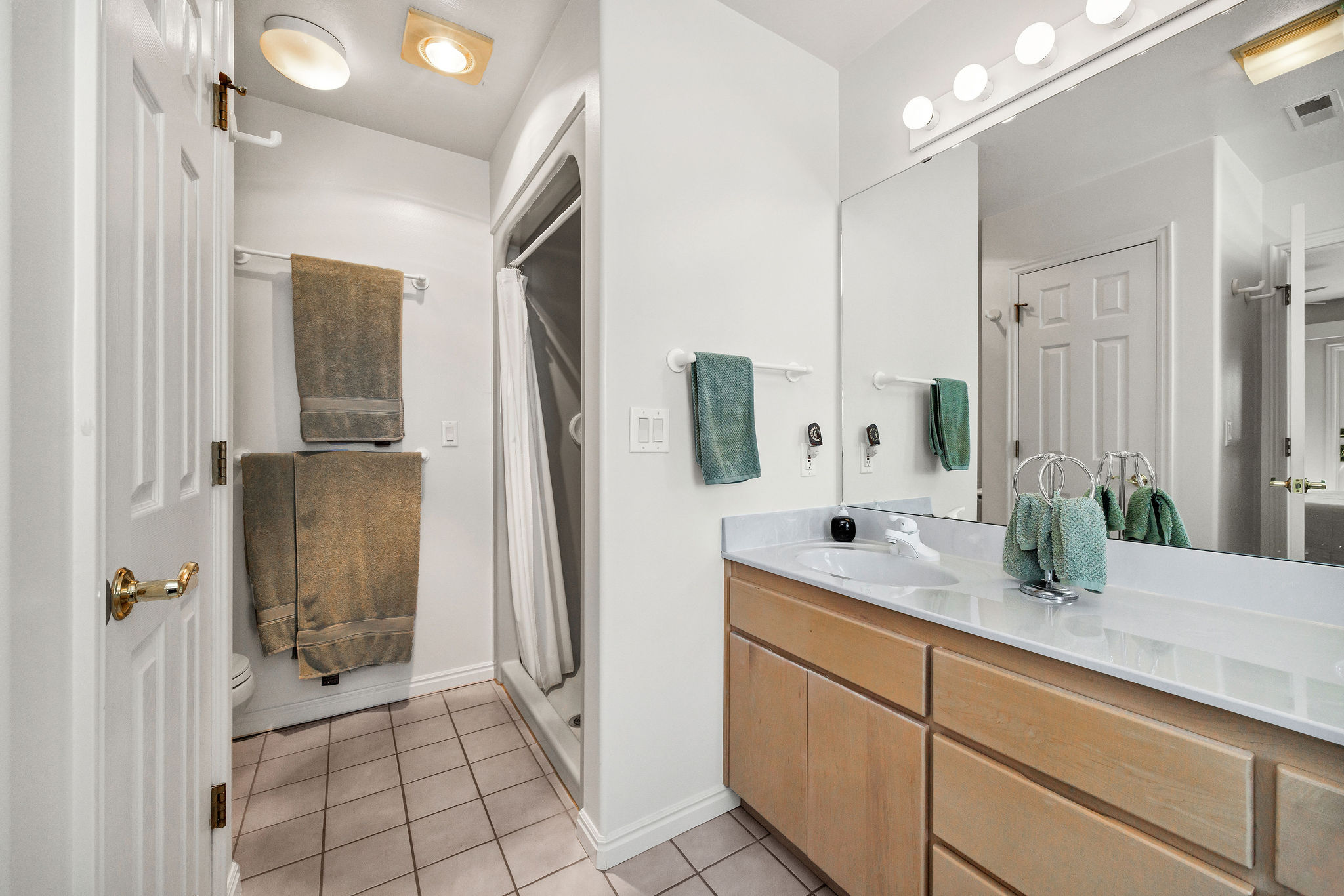 Bathroom with vanity, a shower stall, and light tile patterned floors