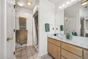 Bathroom with vanity, a shower stall, and light tile patterned floors