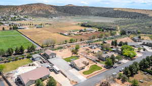 Aerial view of property's location featuring rural landscape, nearby suburban area, and a mountainous background