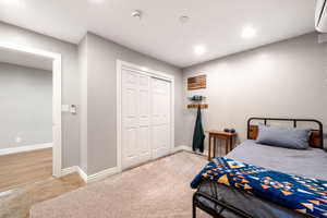 Bedroom with a closet, light colored carpet, and recessed lighting