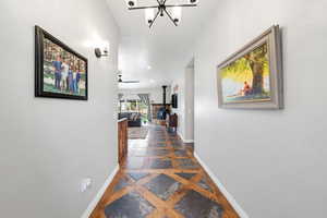 Hallway featuring baseboards and hanging lights
