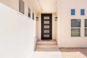 Entrance to property with stucco siding