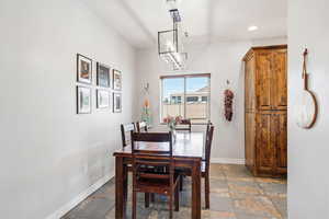 Dining space with stone tile flooring and a chandelier