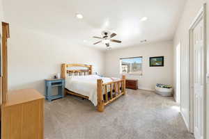 Bedroom with light colored carpet, a ceiling fan, and recessed lighting