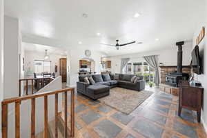 Living area with recessed lighting, a wood stove, healthy amount of natural light, and ceiling fan