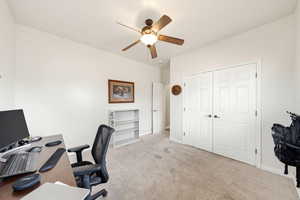 Office area featuring light carpet and a ceiling fan