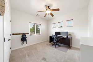 Office area featuring light carpet and ceiling fan
