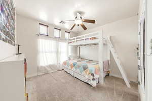 Bedroom with light carpet and a ceiling fan