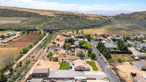 Aerial view of property's location featuring rural landscape, a mountain backdrop, and nearby suburban area