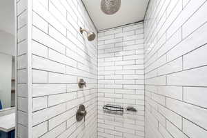 Full bath featuring tiled shower