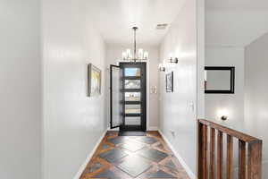 Entryway featuring inlaid floor details and hanging lights