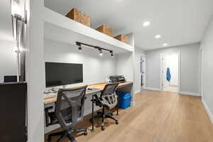 Office area featuring light wood-style flooring and rail lighting