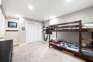 Bedroom with light colored carpet, a closet, and recessed lighting
