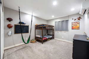 Bedroom with a mini split for heating / cooling, light carpet, and recessed lighting