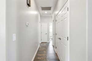Corridor with stone tile flooring and recessed lighting