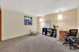 Carpeted office featuring a drop ceiling