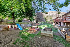 Fenced backyard with a deck with mountain view and a garden