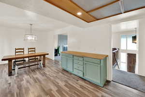 Dining space featuring suspended lighting, a textured ceiling, and light wood finished floors