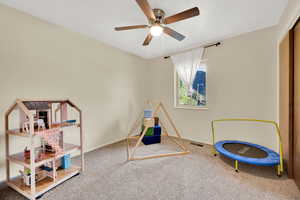 Recreation room with carpet and a ceiling fan