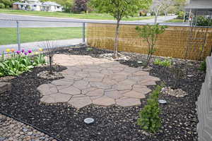 View of fenced front yard with flagstone patio.
