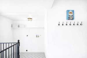 Main floor laundry room featuring hookup for an electric dryer, hookup for a washing machine. One of two laundry rooms.