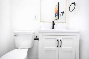 Main floor half bathroom with vanity and toilet