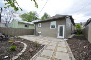 Rear view of house featuring a fenced backyard and a patio area