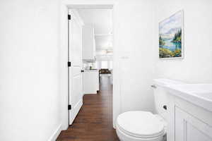 Main floor guest bath, vanity, and dark wood finished floors
