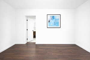 Main floor en-suite bed room featuring dark wood finished floors