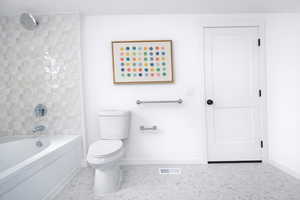 One of two main floor en-suite bathrooms featuring toilet and  shower combination