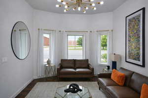 Living room with wood finished floors and hanging lights