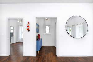 Hallway featuring baseboards and dark wood finished floors