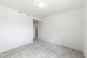 Empty room featuring carpet and baseboards