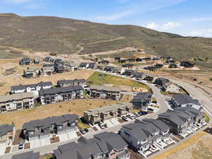 Aerial view of property and surrounding area with nearby suburban area and a mountainous background