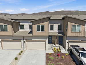 View of front of property with roof with shingles, board and batten siding, a garage, and concrete driveway