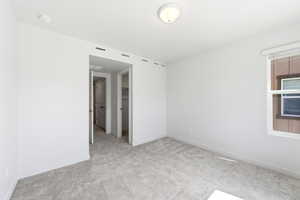 Empty room featuring light carpet and a smoke detector