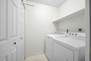 Laundry area featuring washer and clothes dryer and light floors