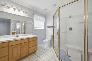 Bathroom with vanity, a shower stall, ornamental molding, and light tile patterned flooring