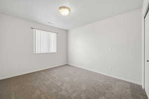 Carpeted empty room with baseboards