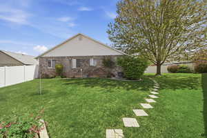 Back of property featuring brick siding and a fenced backyard