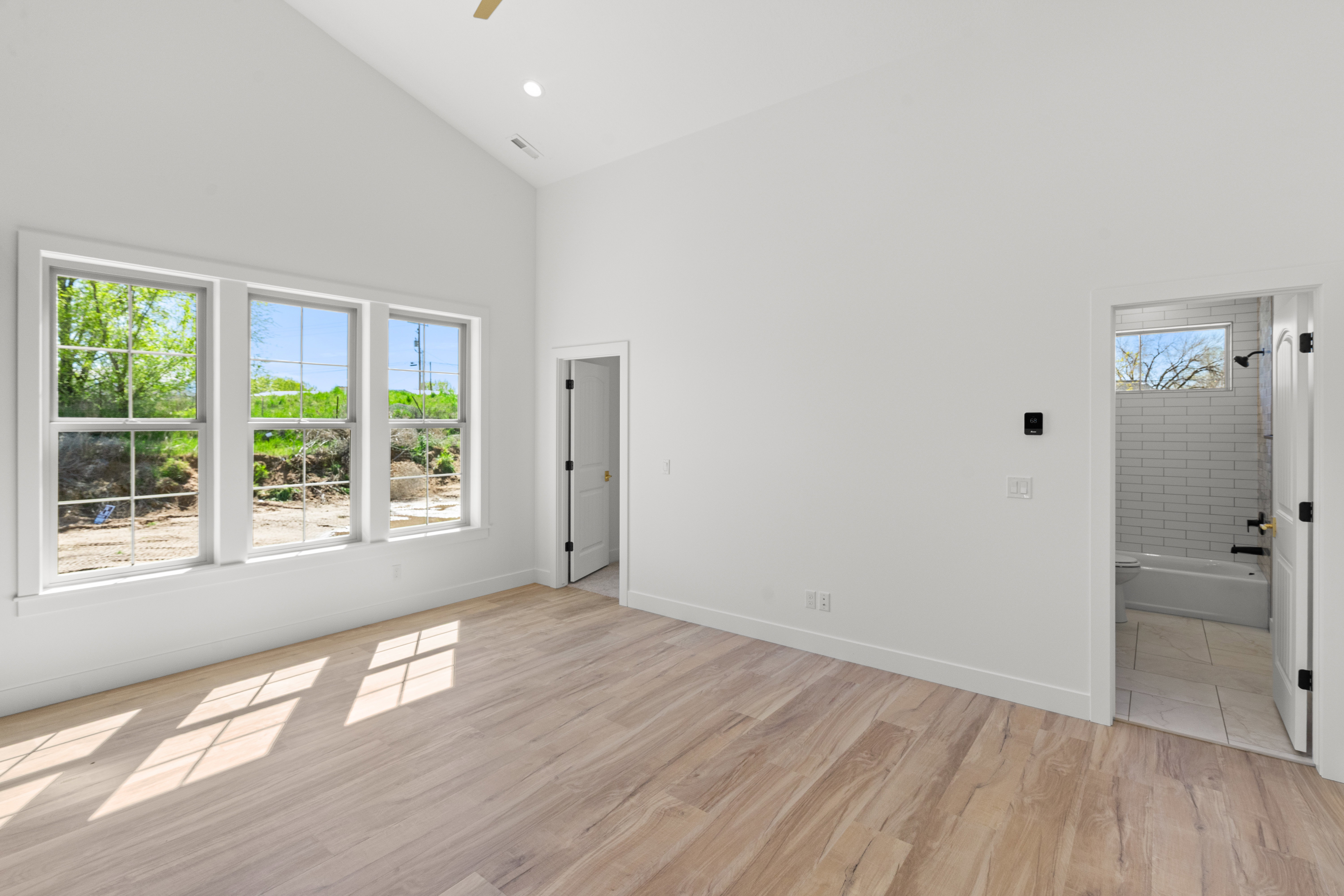 Spare room featuring light wood finished floors, vaulted ceiling, ceiling fan, and recessed lighting
