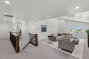 Living room featuring light colored carpet and a chandelier
