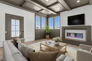 Living room with wood finished floors, plenty of natural light, coffered ceiling, a glass covered fireplace, and recessed lighting