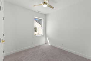 Carpeted spare room with baseboards and a ceiling fan
