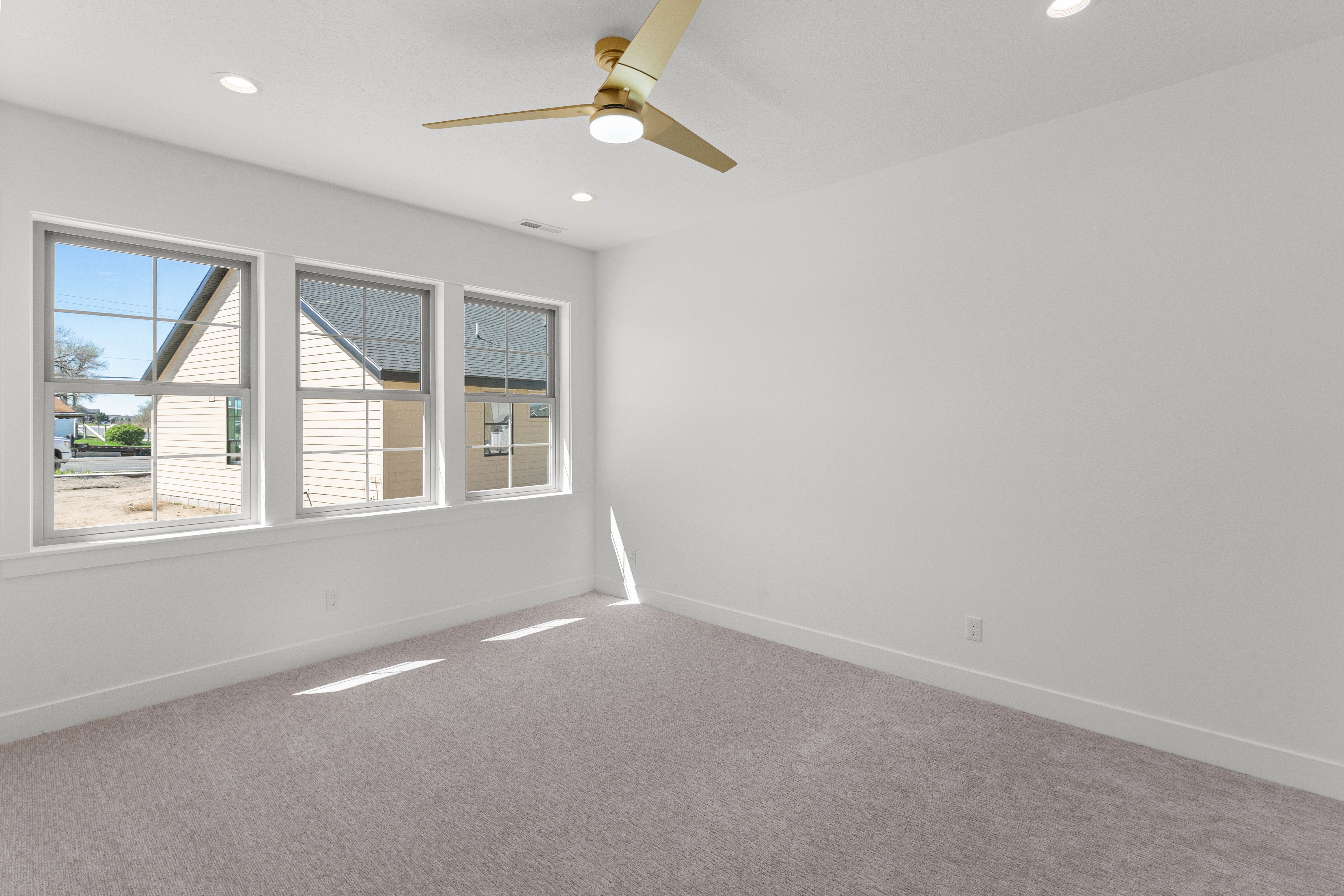 Empty room featuring carpet, ceiling fan, and recessed lighting
