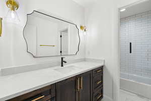 Bathroom with vanity, shower / bath combination with glass door, and light marble finish flooring