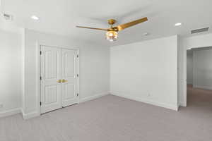 Unfurnished bedroom with recessed lighting, light colored carpet, a ceiling fan, and a closet