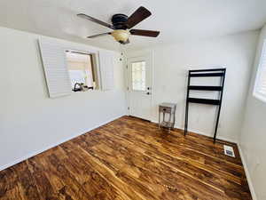Entrance foyer with a ceiling fan, a textured ceiling, and dark wood-style flooring