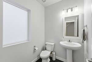 Half Bathroom featuring toilet and tile patterned flooring