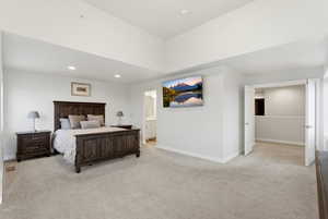 Bedroom featuring light colored carpet, recessed lighting, and ensuite bath